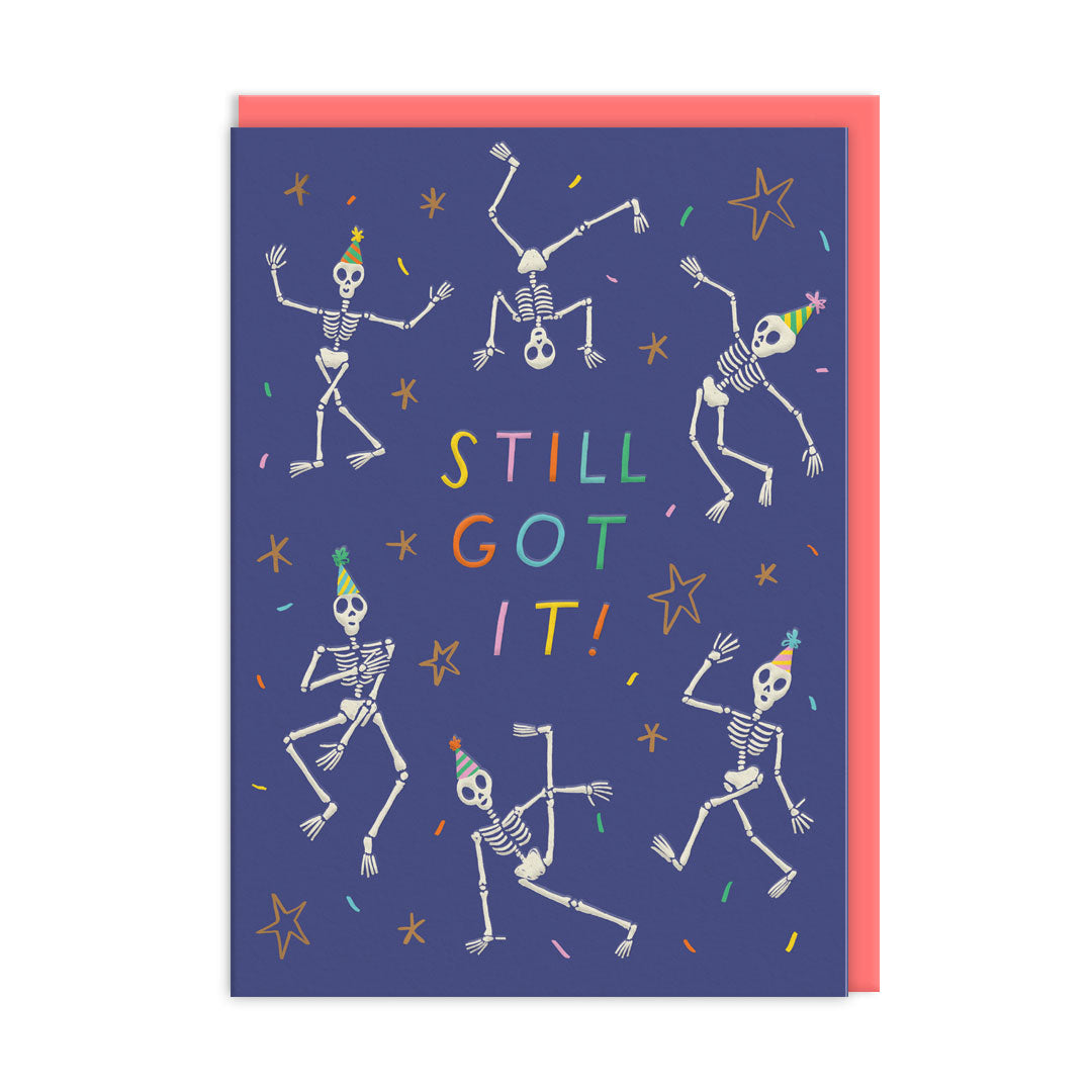 Blue birthday card with illustrations of skeletons dancing. Multi-coloured text reads "Still Got It"
