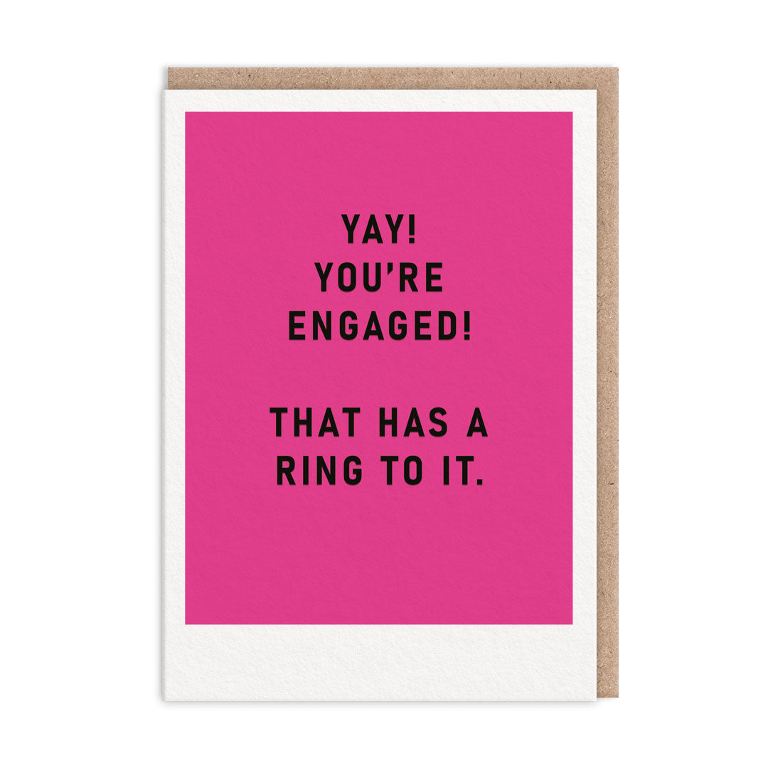 Bright pink engagement card with black foil text that reads "Yay! You're Engaged! That Has A Ring To It"