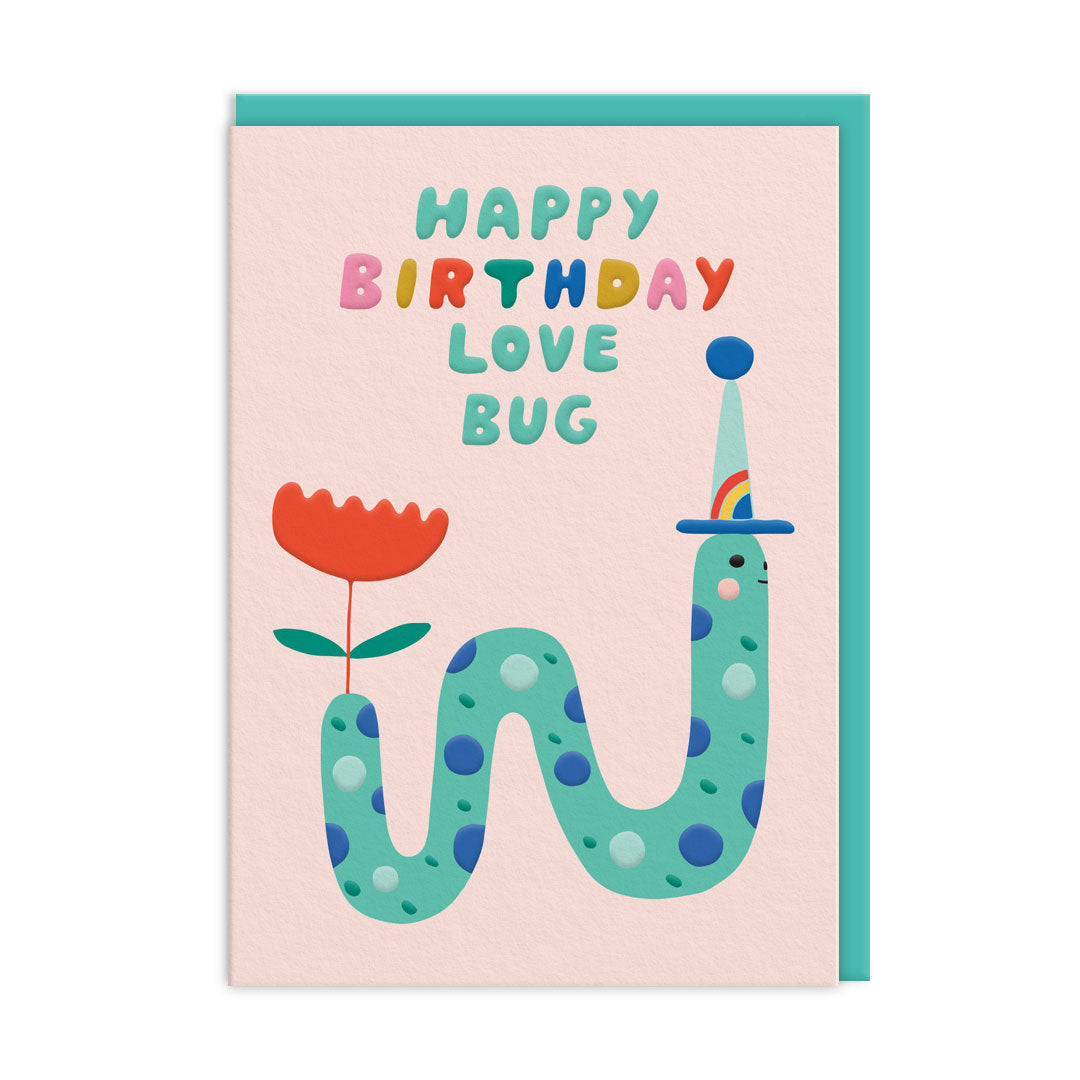 Light pink birthday card with a colourful worm illustration wearing a party hat and a flower. The text reads "Happy Birthday Love Bug"